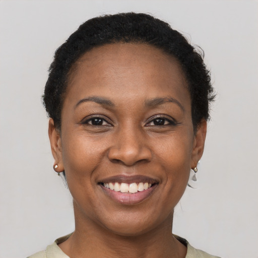 Joyful black young-adult female with short  black hair and brown eyes