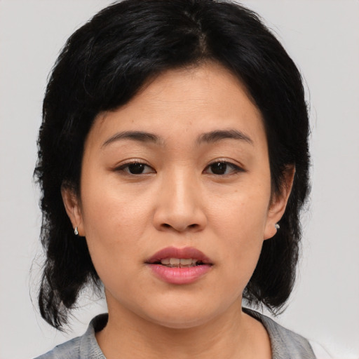 Joyful asian young-adult female with medium  black hair and brown eyes