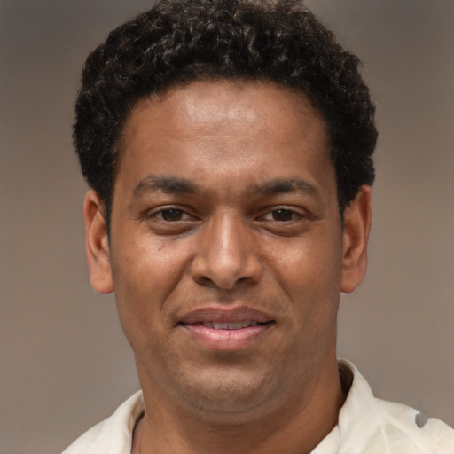 Joyful latino young-adult male with short  brown hair and brown eyes
