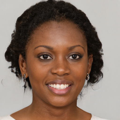 Joyful black young-adult female with medium  brown hair and brown eyes