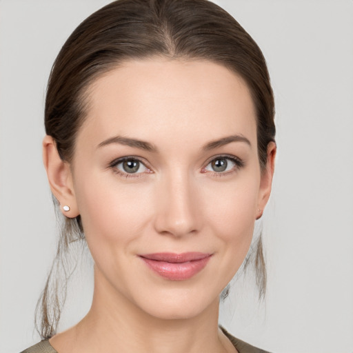 Joyful white young-adult female with medium  brown hair and grey eyes