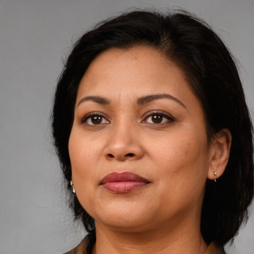 Joyful latino adult female with medium  brown hair and brown eyes