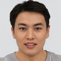 Joyful asian young-adult male with short  brown hair and brown eyes