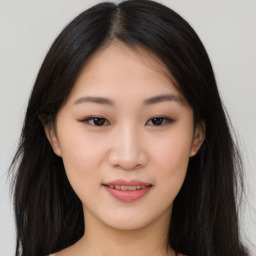 Joyful asian young-adult female with long  brown hair and brown eyes