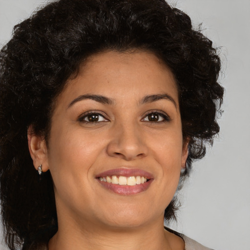 Joyful latino young-adult female with medium  brown hair and brown eyes