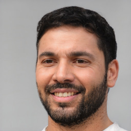 Joyful white adult male with short  black hair and brown eyes