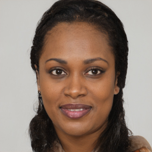 Joyful black young-adult female with long  black hair and brown eyes