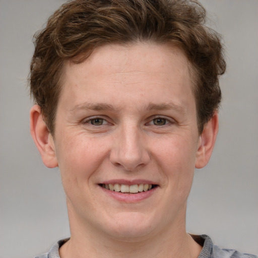 Joyful white adult male with short  brown hair and grey eyes