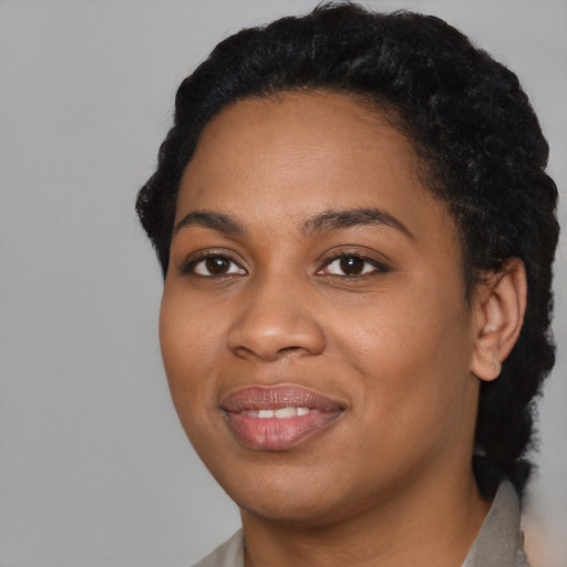 Joyful black young-adult female with short  black hair and brown eyes