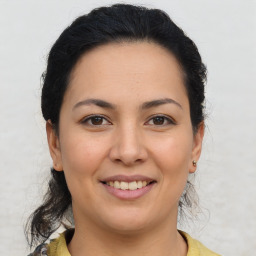 Joyful latino young-adult female with medium  brown hair and brown eyes