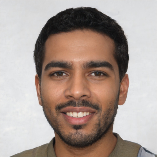 Joyful latino young-adult male with short  black hair and brown eyes