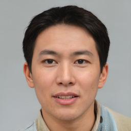 Joyful asian young-adult male with short  brown hair and brown eyes