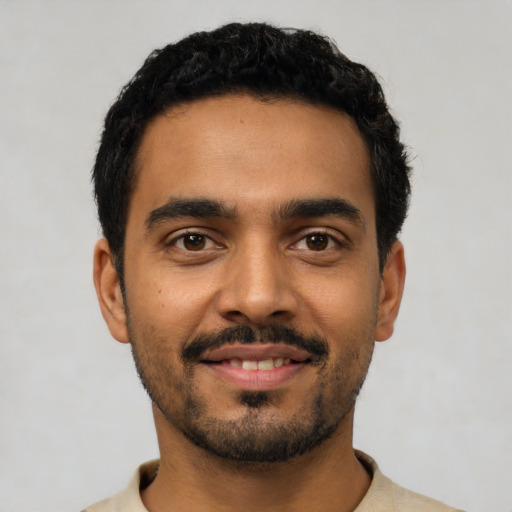 Joyful latino young-adult male with short  black hair and brown eyes