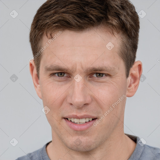 Joyful white young-adult male with short  brown hair and grey eyes