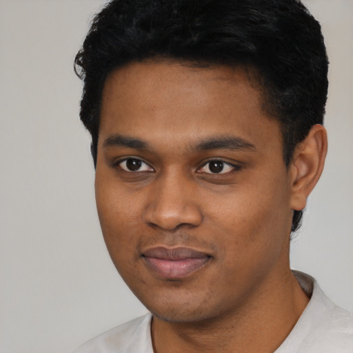 Joyful black young-adult male with short  black hair and brown eyes