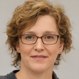 Joyful white adult female with medium  brown hair and blue eyes