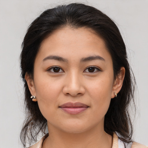 Joyful latino young-adult female with medium  brown hair and brown eyes