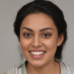 Joyful latino young-adult female with medium  brown hair and brown eyes