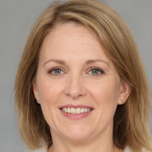 Joyful white adult female with medium  brown hair and grey eyes