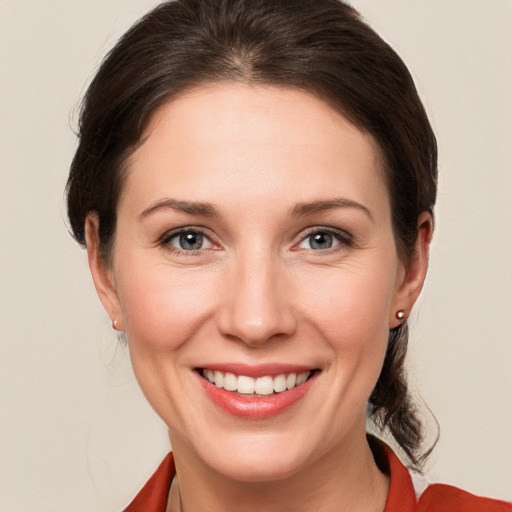 Joyful white young-adult female with medium  brown hair and grey eyes