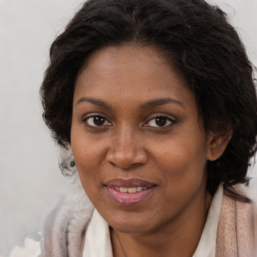 Joyful black adult female with short  brown hair and brown eyes