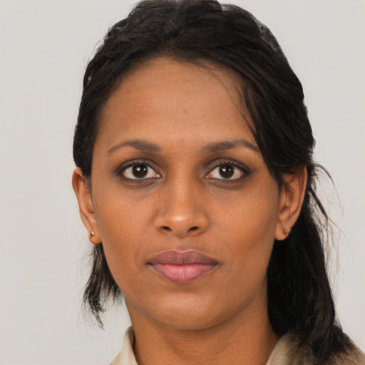 Joyful black young-adult female with long  black hair and brown eyes