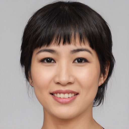 Joyful asian young-adult female with medium  black hair and brown eyes