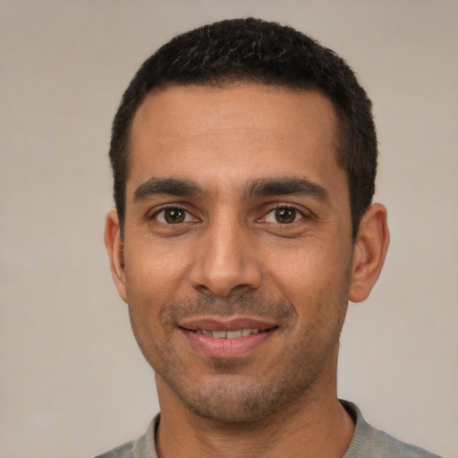 Joyful white young-adult male with short  black hair and brown eyes