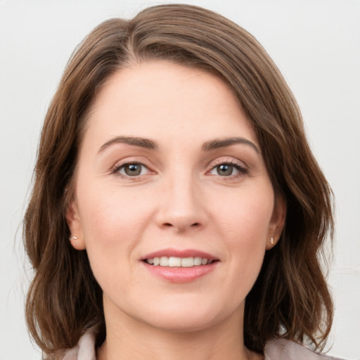 Joyful white young-adult female with medium  brown hair and green eyes