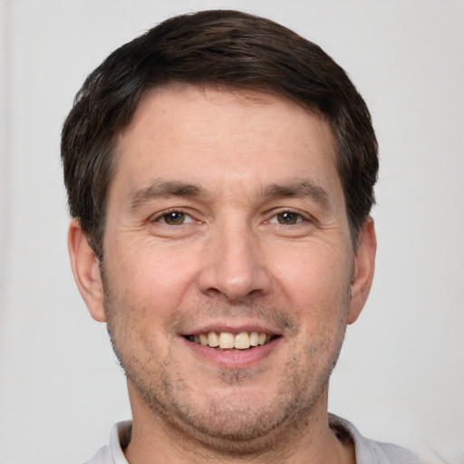 Joyful white adult male with short  brown hair and brown eyes