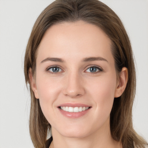 Joyful white young-adult female with long  brown hair and grey eyes