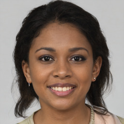 Joyful black young-adult female with medium  brown hair and brown eyes