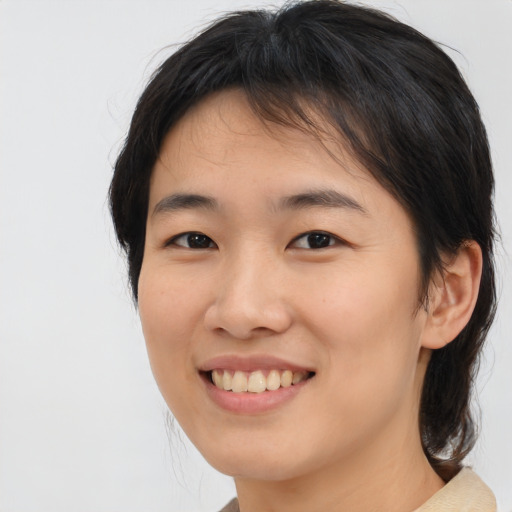 Joyful asian young-adult female with medium  brown hair and brown eyes