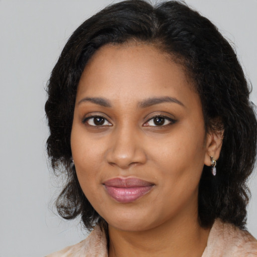 Joyful black young-adult female with long  black hair and brown eyes