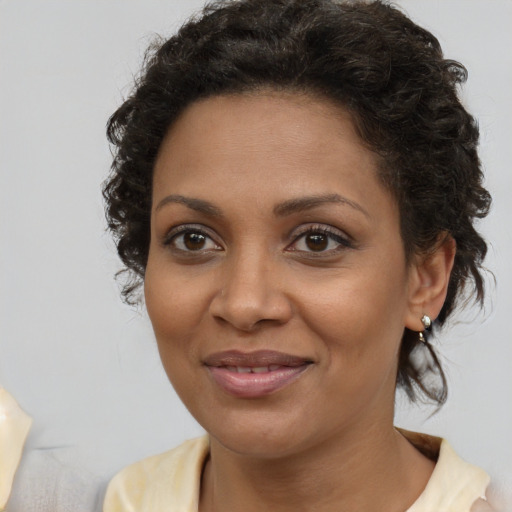 Joyful black young-adult female with medium  brown hair and brown eyes