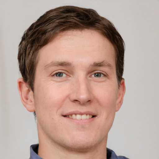 Joyful white adult male with short  brown hair and grey eyes