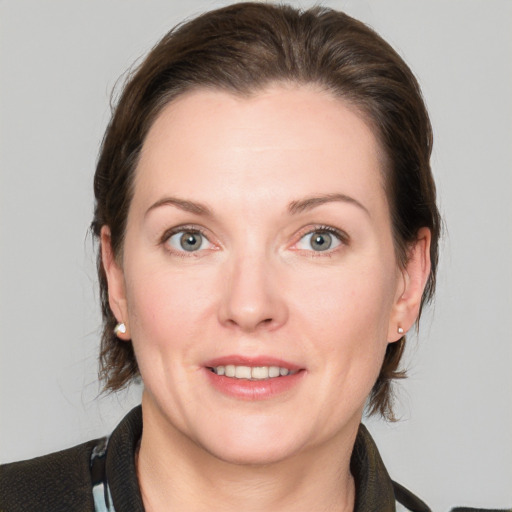 Joyful white adult female with medium  brown hair and grey eyes