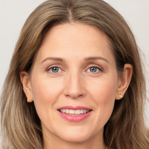 Joyful white adult female with long  brown hair and grey eyes