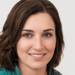 Joyful white young-adult female with long  brown hair and green eyes