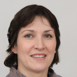 Joyful white adult female with medium  brown hair and grey eyes