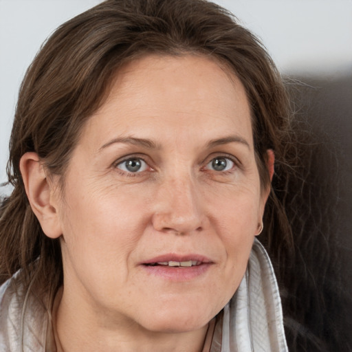 Joyful white adult female with long  brown hair and grey eyes