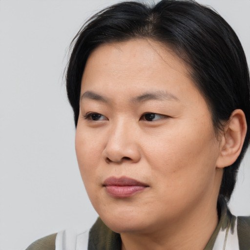 Joyful asian adult female with medium  brown hair and brown eyes
