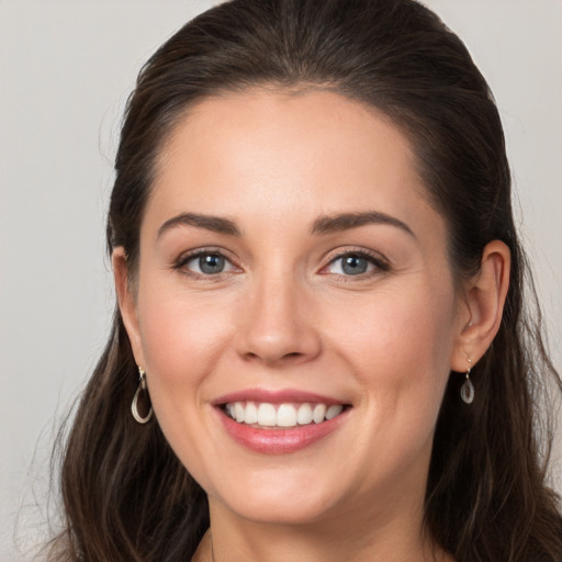 Joyful white young-adult female with long  brown hair and grey eyes