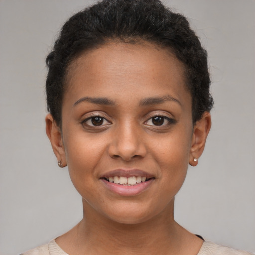 Joyful black young-adult female with short  brown hair and brown eyes