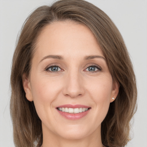 Joyful white young-adult female with medium  brown hair and grey eyes