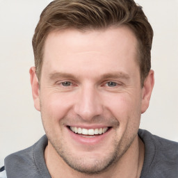 Joyful white young-adult male with short  brown hair and grey eyes