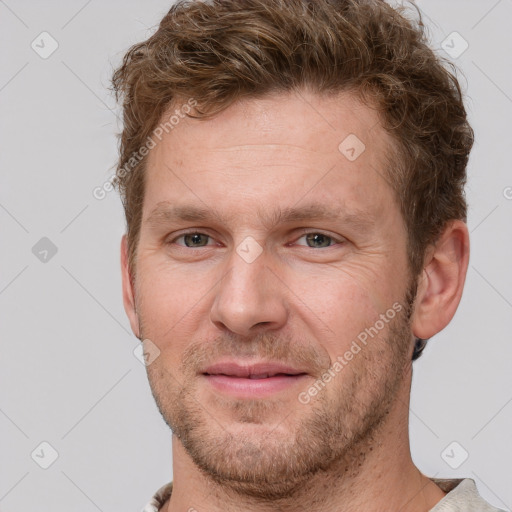 Joyful white adult male with short  brown hair and grey eyes