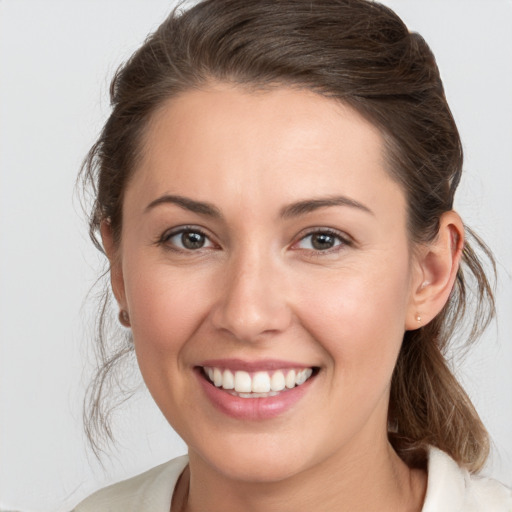 Joyful white young-adult female with medium  brown hair and grey eyes