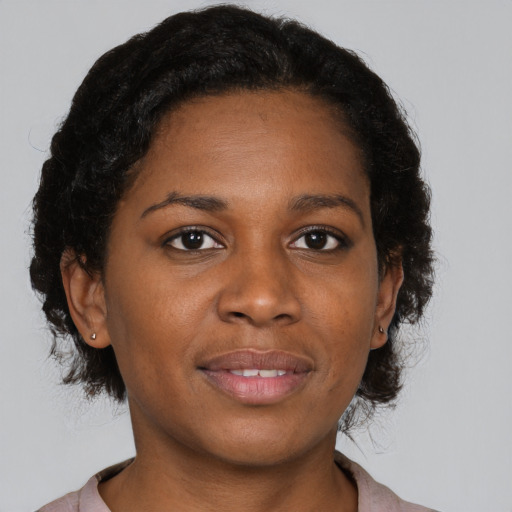 Joyful black young-adult female with short  brown hair and brown eyes