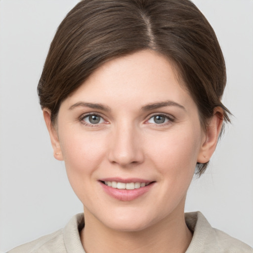 Joyful white young-adult female with short  brown hair and grey eyes